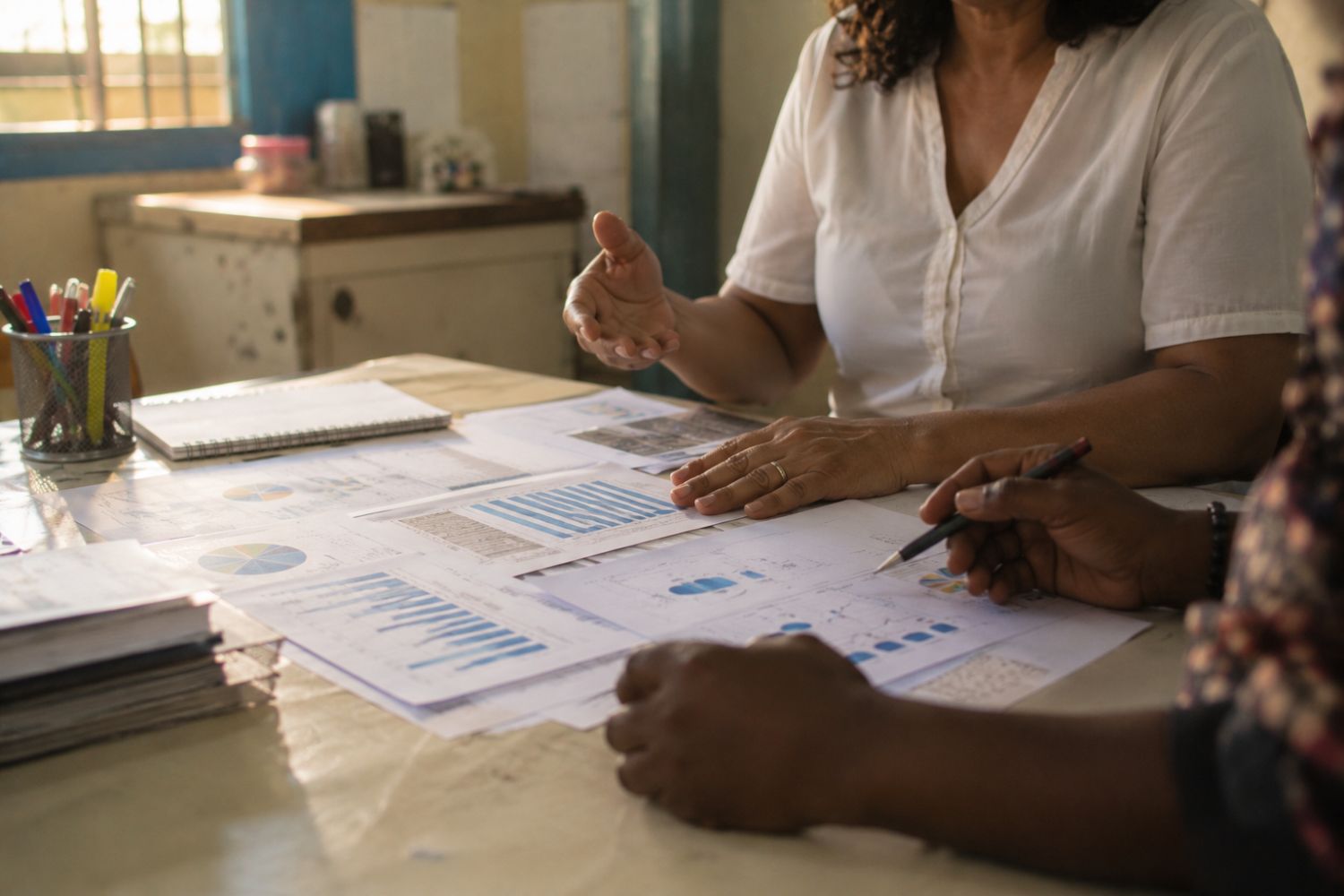 Equipe gestora analisa gráficos e relatórios em uma mesa da escola